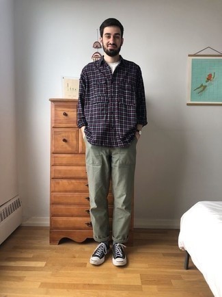 500+ Summer Outfits For Men: Exhibit your credentials in men's fashion in this off-duty pairing of a navy plaid long sleeve shirt and olive chinos. Black and white canvas low top sneakers pull the look together. Undoubtedly, it's easier to work through a hot summer day in a breezy look like this one.