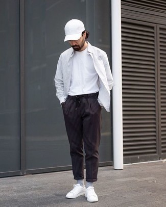 Black Vertical Striped Chinos Outfits: Reach for a white vertical striped long sleeve shirt and black vertical striped chinos if you wish to look casually cool without too much effort. All you need is a pair of white leather low top sneakers to finish your ensemble.