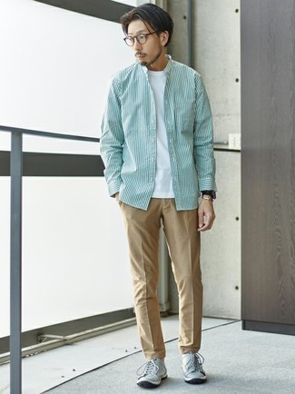 White and Green Vertical Striped Long Sleeve Shirt Outfits For Men: Effortlessly blurring the line between dapper and off-duty, this pairing of a white and green vertical striped long sleeve shirt and khaki chinos will easily become your go-to. Grey leather low top sneakers are the glue that ties your outfit together.