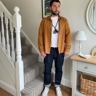 White and Red Canvas Low Top Sneakers Outfits For Men: Want to inject your closet with some laid-back dapperness? Dress in a tobacco long sleeve shirt and navy jeans. Complement this look with a pair of white and red canvas low top sneakers and the whole outfit will come together.