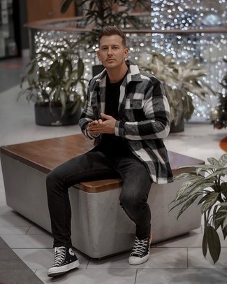 White and Black Check Long Sleeve Shirt Outfits For Men: If you're a fan of classic combos, then you'll love this combination of a white and black check long sleeve shirt and charcoal jeans. Tone down the classiness of this ensemble by sporting black print canvas high top sneakers.