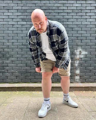 Beige Denim Shorts Outfits For Men: Reach for a navy and white plaid long sleeve shirt and beige denim shorts for a cool and trendy outfit. If not sure about what to wear on the shoe front, complement this outfit with white and black leather low top sneakers.