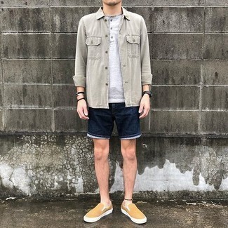 500+ Warm Weather Outfits For Men: Hard proof that a grey long sleeve shirt and navy denim shorts are amazing when teamed together in a laid-back look. Tan canvas slip-on sneakers are a nice pick to round off this ensemble.