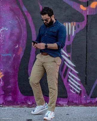 White and Black Athletic Shoes Outfits For Men: This combo of a navy chambray long sleeve shirt and khaki ripped jeans is irrefutable proof that a straightforward casual outfit doesn't have to be boring. Amp up your look by finishing with a pair of white and black athletic shoes.