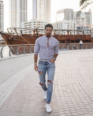 White and Navy Long Sleeve Shirt Outfits For Men: Reach for a white and navy long sleeve shirt and light blue ripped jeans if you seek to look casually stylish without trying too hard. Rounding off with a pair of white and black leather low top sneakers is a surefire way to breathe a dose of class into this look.