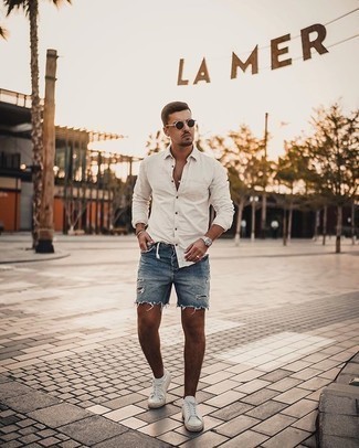 Blue Ripped Denim Shorts Outfits For Men: This combo of a white long sleeve shirt and blue ripped denim shorts is undeniable proof that a pared down casual outfit can still be really interesting. And if you wish to easily rev up this ensemble with footwear, why not complete this ensemble with a pair of white canvas low top sneakers?