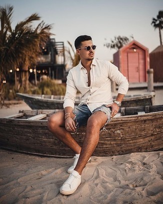 Navy Ripped Denim Shorts Outfits For Men: If you feel more confident in practical clothes, you'll love this street style pairing of a white long sleeve shirt and navy ripped denim shorts. Go off the beaten path and shake up your getup by finishing off with white canvas low top sneakers.