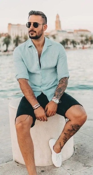 Black Denim Shorts Outfits For Men: A light blue long sleeve shirt looks especially cool when married with black denim shorts. Add a pair of white canvas low top sneakers to this getup and the whole outfit will come together quite nicely.