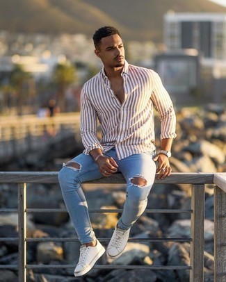 Light Blue Ripped Skinny Jeans Outfits For Men: To don an off-duty look with an edgy twist, you can easily rock a brown vertical striped long sleeve shirt and light blue ripped skinny jeans. For something more on the elegant side to finish off your outfit, add white canvas low top sneakers to the mix.