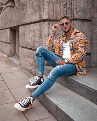 Brown Plaid Long Sleeve Shirt Outfits For Men: This pairing of a brown plaid long sleeve shirt and blue ripped skinny jeans is on the casual side but also ensures that you look stylish and razor-sharp. This look is complemented perfectly with a pair of black print canvas high top sneakers.