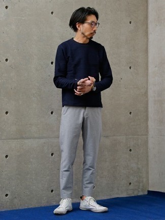 Navy Long Sleeve T-Shirt Outfits For Men: Flaunt your skills in men's fashion by opting for this relaxed casual combination of a navy long sleeve t-shirt and grey chinos. A pair of white canvas low top sneakers integrates smoothly within a great deal of ensembles.