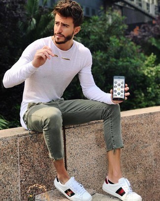 Olive Jeans Outfits For Men: This combo of a white long sleeve t-shirt and olive jeans is well-executed and yet it's comfortable enough and ready for anything. If you're wondering how to finish, a pair of white print leather low top sneakers is a safe option.