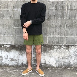 Dark Green Sports Shorts Outfits For Men: Go for a black long sleeve t-shirt and dark green sports shorts to achieve an interesting and relaxed outfit. You can get a bit experimental in the shoe department and add tan canvas slip-on sneakers to the equation.