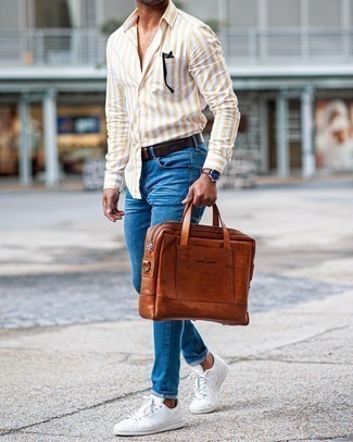 Men's Brown Leather Briefcase, White Leather Low Top Sneakers, Blue Skinny Jeans, Yellow Vertical Striped Long Sleeve Shirt