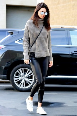 Kendall Jenner wearing Black Leather Crossbody Bag, White Low Top Sneakers, Black Leather Skinny Pants, Grey Knit Turtleneck