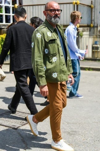 Olive Military Jacket with White Leather Low Top Sneakers Spring Outfits For Men: For a casual look with a modern spin, wear an olive military jacket with tobacco chinos. You can take a more casual approach with shoes and complement this look with white leather low top sneakers. Keep this combination in mind come spring, and rest assured, you'll save time brainstorming for an outfit on more than one occasion.