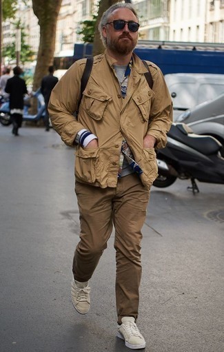 Khaki Military Jacket Outfits For Men: This combo of a khaki military jacket and brown chinos is proof that a pared down casual look can still be really interesting. To give your outfit a more relaxed finish, why not add beige canvas low top sneakers to the equation?