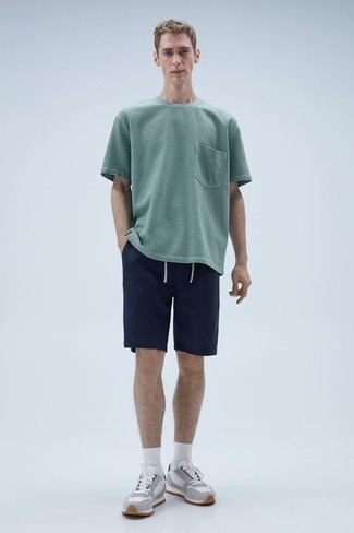 500+ Summer Outfits For Men: A mint crew-neck t-shirt and navy shorts? This is easily a wearable ensemble that you could sport on a day-to-day basis. A pair of grey athletic shoes easily turns up the fashion factor of this ensemble. Both stylish and summer-friendly, you can rock a version of this look throughout the summer.
