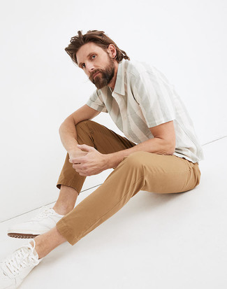 White and Green Vertical Striped Short Sleeve Shirt Outfits For Men: For a casual and cool look, go for a white and green vertical striped short sleeve shirt and khaki chinos — these two pieces fit nicely together. Introduce white leather low top sneakers to your ensemble and the whole outfit will come together perfectly.