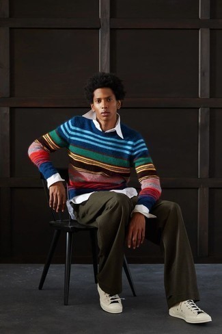 Men's Outfits 2022: On days when comfort is the priority, pair a multi colored horizontal striped crew-neck sweater with olive chinos. Beige canvas low top sneakers integrate really well within a ton of ensembles.
