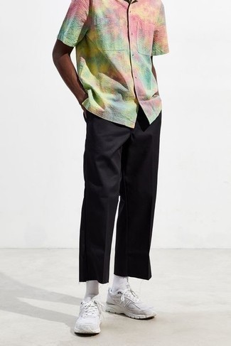 Black Chinos Summer Outfits: Go for a simple but at the same time casually cool choice in a multi colored tie-dye short sleeve shirt and black chinos. White athletic shoes are guaranteed to add an element of stylish nonchalance to this getup. Loving how perfect this getup is when summer settles in.