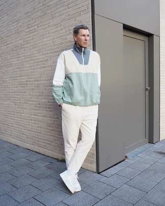 Multi colored Windbreaker Outfits For Men: This is solid proof that a multi colored windbreaker and beige jeans look amazing when worn together in a casual outfit. Complement your getup with a pair of white leather low top sneakers and the whole ensemble will come together.