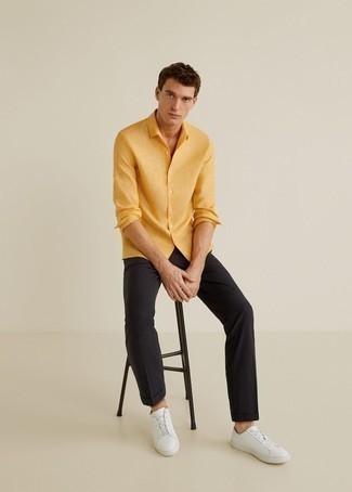 Mustard Long Sleeve Shirt Outfits For Men: Choose a mustard long sleeve shirt and black chinos to pull together a seriously stylish and modern-looking off-duty ensemble. You can get a little creative in the shoe department and grab a pair of white leather low top sneakers.