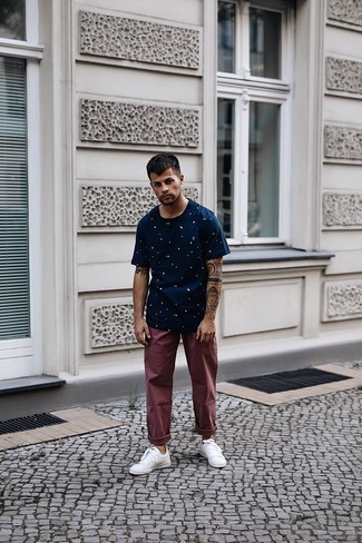 Burgundy Chinos Hot Weather Outfits: A big thumbs up to this relaxed combo of a navy and white print crew-neck t-shirt and burgundy chinos! If you're clueless about how to round off, a pair of white canvas low top sneakers is a fail-safe option.