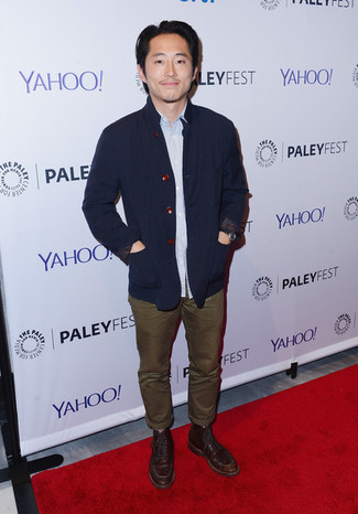 Steven Yeun wearing Navy Cotton Blazer, Light Blue Long Sleeve Shirt, Olive Chinos, Dark Brown Leather Casual Boots