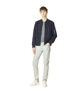 Navy Bomber Jacket Outfits For Men: To don a casual getup with a clear fashion twist, you can opt for a navy bomber jacket and light blue jeans. White canvas low top sneakers will pull the whole thing together.