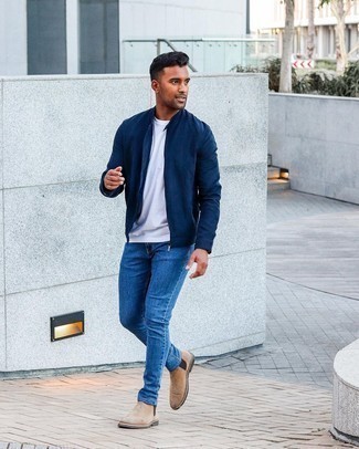 Navy Bomber Jacket Outfits For Men: Extremely stylish and comfortable, this casual pairing of a navy bomber jacket and blue jeans provides with ample styling possibilities. Tap into some David Gandy dapperness and elevate your getup with a pair of tan suede chelsea boots.