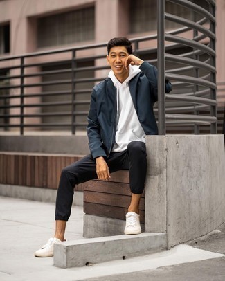 Navy Bomber Jacket Outfits For Men: This look with a navy bomber jacket and black chinos isn't so hard to pull off and is easy to change according to circumstances. A pair of white canvas low top sneakers effortlessly turns up the appeal of this getup.