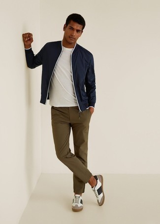 Navy Bomber Jacket Outfits For Men: Dress in a navy bomber jacket and olive chinos if you seek to look cool and casual without too much effort. And if you want to immediately play down this outfit with one single piece, introduce a pair of white and black leather low top sneakers to the equation.
