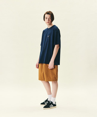 1200+ Hot Weather Outfits For Men: You'll be amazed at how extremely easy it is for any guy to pull together this casual outfit. Just a navy crew-neck t-shirt worn with tobacco shorts. Black and white suede low top sneakers finish off this outfit very nicely.