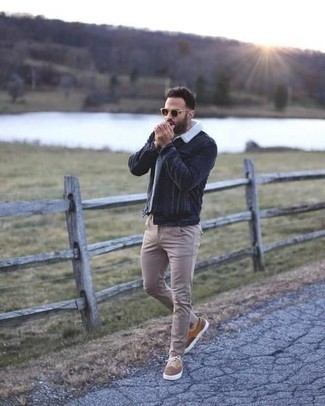 Tan Canvas Low Top Sneakers Outfits For Men: Opt for a navy denim jacket and beige chinos to put together a laid-back and cool ensemble. For something more on the daring side to finish off your look, complement this look with a pair of tan canvas low top sneakers.