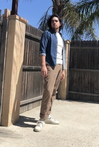 Blue Denim Shirt Casual Outfits For Men: This combination of a blue denim shirt and khaki chinos is impeccably stylish and yet it looks comfortable enough and apt for anything. White leather low top sneakers look amazing here.