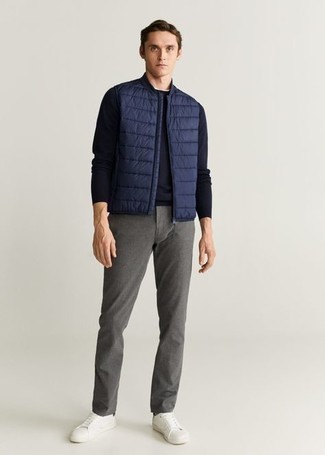 Blue Quilted Gilet Outfits For Men: This combination of a blue quilted gilet and grey chinos makes for the perfect foundation for a casual and cool outfit. Complement this outfit with white canvas low top sneakers and the whole look will come together.