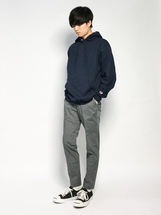 Navy Hoodie Outfits For Men: This laid-back combination of a navy hoodie and grey chinos is a safe bet when you need to look dapper in a flash. Black and white canvas low top sneakers will tie this whole look together.