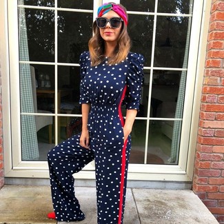Red Suede Pumps Summer Outfits: Consider wearing a navy polka dot jumpsuit for a laid-back spin on off-duty outfits. To bring out a sophisticated side of you, introduce a pair of red suede pumps to your ensemble. Clearly, you're looking at a smart option for a blazing hot warm weather day.