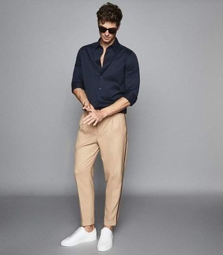 Navy Long Sleeve Shirt Outfits For Men: You're looking at the indisputable proof that a navy long sleeve shirt and khaki chinos are awesome when combined together in a laid-back outfit. When this look is just too much, play it down by slipping into white leather low top sneakers.