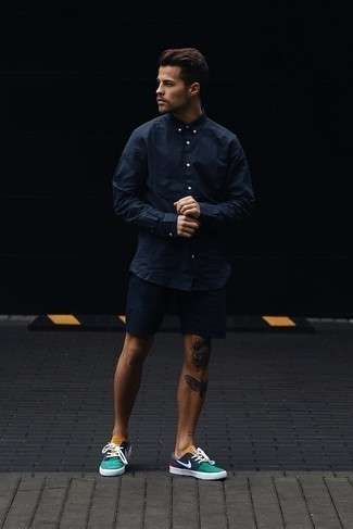 Navy Shorts Outfits For Men: This combination of a navy long sleeve shirt and navy shorts is on the casual side but will guarantee that you look stylish and extra stylish. Multi colored canvas low top sneakers pull the outfit together.
