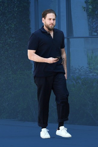 Jonah Hill wearing Navy Polo, Navy Chinos, White Leather Low Top Sneakers, Black Socks