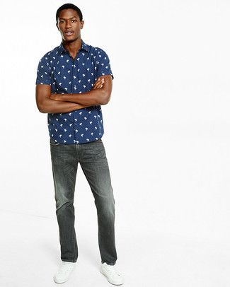 Navy and White Print Short Sleeve Shirt Outfits For Men: This pairing of a navy and white print short sleeve shirt and charcoal jeans is hard proof that a pared down casual look doesn't have to be boring. White leather low top sneakers are a great option to round off your ensemble.