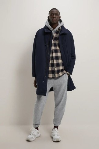Navy Raincoat Outfits For Men: To create a casual getup with a modernized spin, you can easily go for a navy raincoat and a multi colored plaid flannel long sleeve shirt. Go ahead and complement this ensemble with a pair of white athletic shoes for a more laid-back spin.