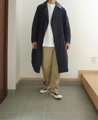 Navy Raincoat Outfits For Men: If you need to feel confident in your outfit, choose a navy raincoat and khaki chinos. Black and white canvas low top sneakers are a stylish complement to this ensemble.