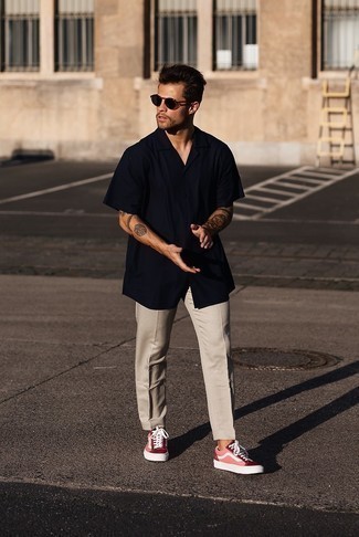 Hot Pink Canvas Low Top Sneakers Outfits For Men: For a casually stylish outfit, dress in a navy short sleeve shirt and beige chinos — these two pieces fit pretty good together. Complete this getup with hot pink canvas low top sneakers for extra style points.