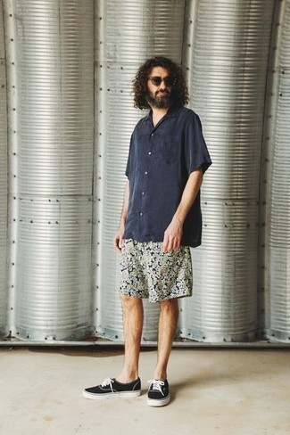 Navy Short Sleeve Shirt Outfits For Men: The styling capabilities of a navy short sleeve shirt and navy floral shorts guarantee you'll have them on permanent rotation in your menswear collection. Look at how nice this ensemble is rounded off with a pair of black and white canvas low top sneakers.
