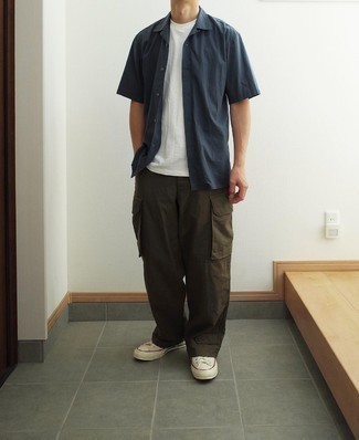 Olive Cargo Pants Outfits: A navy short sleeve shirt and olive cargo pants are the kind of a no-brainer casual look that you so terribly need when you have no extra time to spare. A pair of white canvas low top sneakers is a great choice to finish this ensemble.
