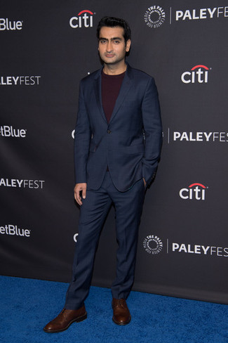 Kumail Nanjiani wearing Navy Suit, Burgundy Crew-neck Sweater, Dark Brown Leather Derby Shoes