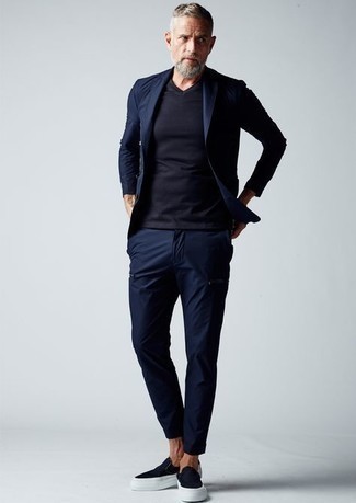 Navy Suit Outfits: A navy suit and a navy v-neck t-shirt make for the perfect base for a myriad of outfits. Finishing with a pair of navy canvas slip-on sneakers is a fail-safe way to bring a mellow vibe to your look.